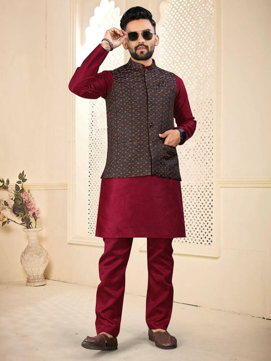 Man wearing a maroon kurta with a patterned vest in a decorative room.